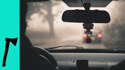 Innenansicht eines Autos, Bremslichter eines anderen Autos sind durch die Frontscheibe ominös zu beobachten.