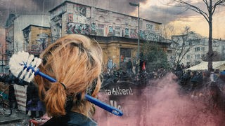 Person mit einer Klobürste im Haar, im Hintergrund Demonstranten vor einem besetzten Gebäude.