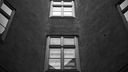 Schwarz-weiß und düster: Innenhof mit Blick auf die Fensterfont.