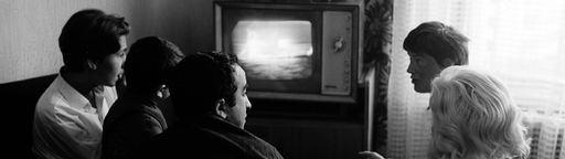 Eine Familie sitzt am Fernsehen und schaut die Mondlandung von 1969.