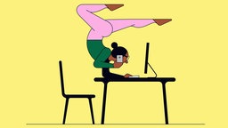 Frau macht einen Yoga Handstand während sie am Computer arbeitet.