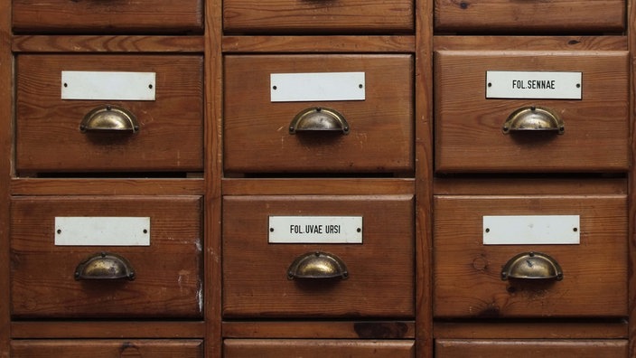 Sechs Holzschubladen in einem Schrank.