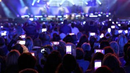 Smartphones vieler Menschen filmen ein Konzert.