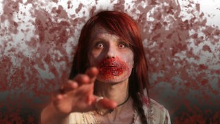 Eine Frau als Zombie kostümiert nimmt am einem Zombie-Walk teil.