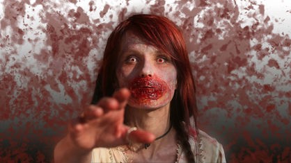 Eine Frau als Zombie kostümiert nimmt am einem Zombie-Walk teil.