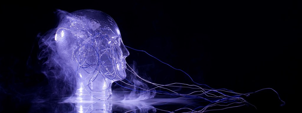 Ein künstlicher Kopf ist mit blau beleuchteten Kabeln verbunden, der Hintergrund ist schwarz.