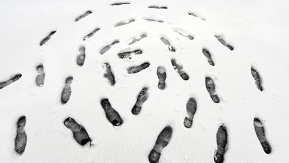 Fußspuren im Schnee bilden einen Kreis.