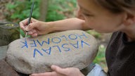Eine Betreuerin des Sommercamps der Aktion Sühnezeichen arbeitet in Buchenwald (Thüringen) an einem Gedenkstein für ein deportiertes Kind. 