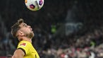 Dortmunds Mittelstürmer Niclas Füllkrug köpft und schaut hoch zum Ball - Großaufnahme