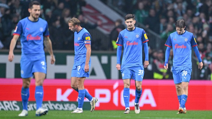 Spielszene: Spieler von Holstein Kiel mit hängenden Köpfen auf dem Platz (Steven Skrzybski, Timo Becker , Armin Gigovic, Magnus Knudsen)