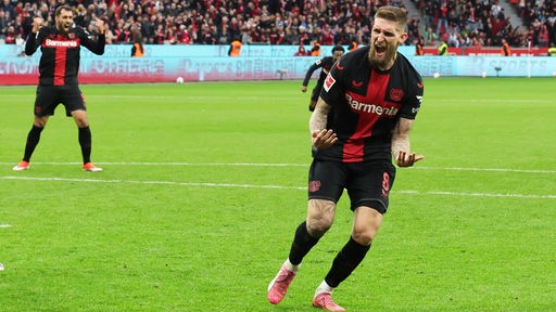 Leverkusens Robert Andrich freut sich, Teamkollegen kommen herangelaufen