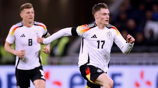 Länderspiel-Szene: Florian Wirtz rennt vor Toni Kroos im deutschen Dress über das Spielfeld