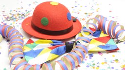 Karneval Symbolbild mit Konfetti, Luftschlangen sowie buntem Hut und bunter Fliege