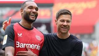 Leverkusens Trainer Xabi Alonso (rechts) mit Spieler Jonathan Tah