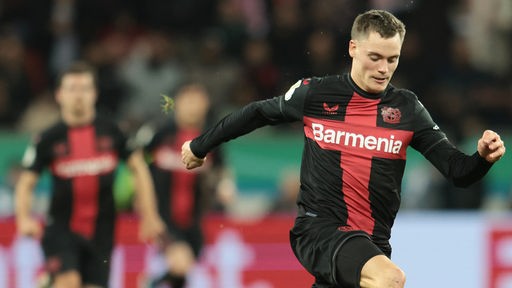 Leverkusens Florian Wirtz stürmt in Pokalspiel über den Platz, dahinter unscharf Mitspieler
