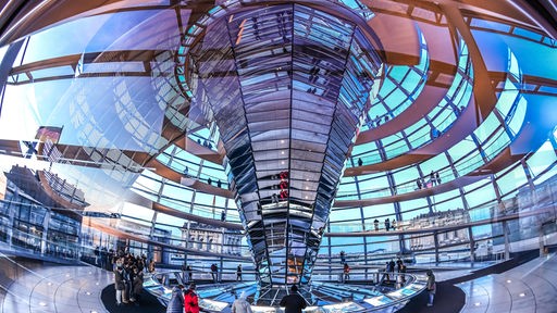 Besucher laufen durch die gläserne Reichstagskuppel