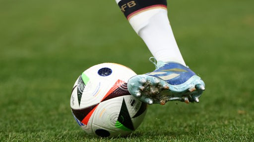 Offizieller Spielball der UEFA EURO 2024 wird geschossen, man erkennt auf der Socke des Spielers die Aufschrift DFB (Nahaufnahme)