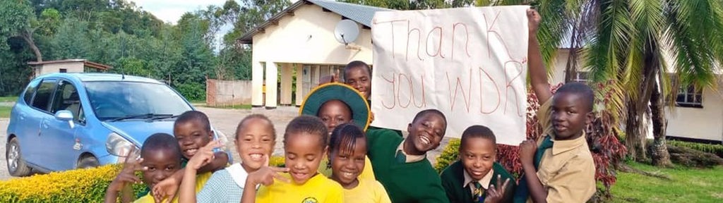 Kinder aus Simbabwe halten ein "Thank you WDR" Schild hoch 
