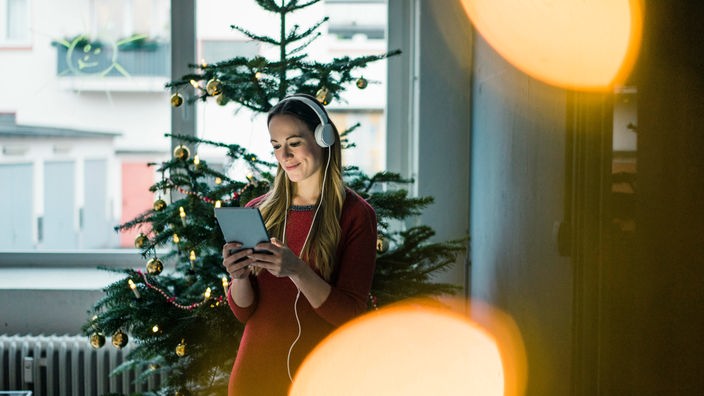 WDR 2 Weihnachtswunder: Frau hört Musik vor Tannenbaum