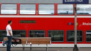 Ein Reisender steht im Hauptbahnhof Essen vor einem Regionalzug