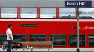 Ein Reisender steht im Hauptbahnhof Essen vor einem Regionalzug