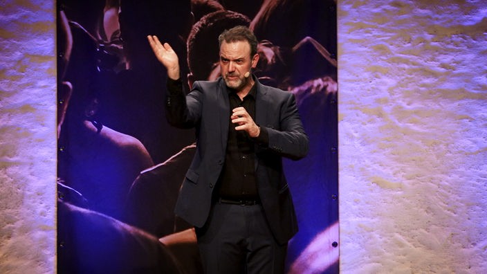 Comedian René Steinberg gestikuliert auf der Bühne bei der Aschermittwochsshow