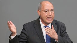 Gregor Gysi gestikuliert am Rednerpult des Deutschen Bundestages