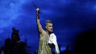 Robbie Williams schwingt seinen Mikro-Ständer