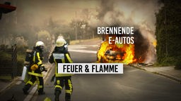 Zwei Feuerwehrleute laufen Richtung explodiertes E-Auto