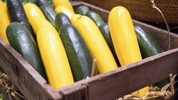 Gelbe und grüne Zucchini in einer Holzkiste 