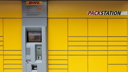 Eine gelbe Paketstation der DHL in der Totalen