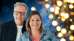 WDR 2 Moderatoren Conny Raupold und Jan Malte Andresen vor weihnachtlichem Hintergrund