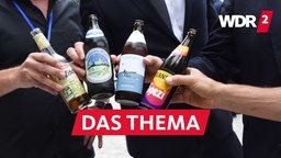 Vier Männer stoßen zur Eröffnung von Münchens erstem Biergarten ohne Alkohol mit alkoholfreien Getränken an