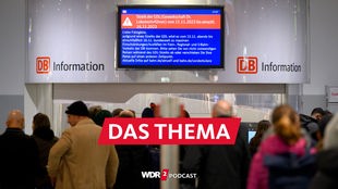 Reisende warten vor einem Informationszentrum der DB, wo ein Bildschirm auf den Streik der GDL am 15. und 16.11.2023  hinweist