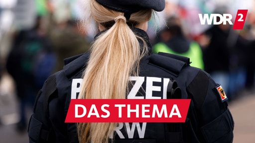 Eine Polizistin steht bei einer pro-kurdischen Demonstration in Köln am 17.02.2024 am Rand des Demonstrationszuges