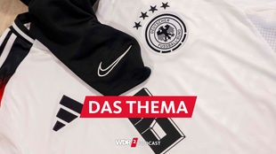 Ein Trikot der deutschen Fußball-Nationalmannschaft von adidas, auf dem eine Sportbekleidung mit dem Nike-Logo liegt