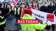 Mit Trommelschlägen und Transparenten beteiligen sich Gewerkschaftsmitglieder an einer Streik-Kundgebung von Verdi