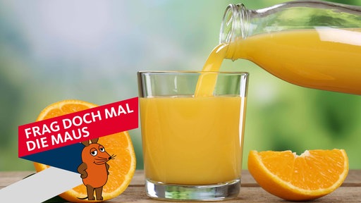 Aus einer Karaffe wird Orangensaft in ein Glas gegossen, daneben eine aufgeschnittene Orange