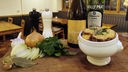 Überbackene französische Zwiebelsuppe in einer Schüssel und Zutaten