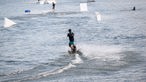 Mehrere Wasserskifahrer sind auf einem See unterwegs