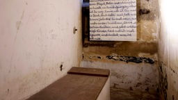 Beim Pressetermin zur Neueröffnung der Gedenkstätte am 04.06.2024: Zelle mit Pritsche in der ehemaligen Arbeitsanstalt sowie einen Zettel mit Handschrift