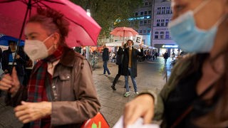 70 Jahre Musik der Zeit: Ein Guide wartet mit einem Schild auf "seinde Guppe" für den musikalischen Rundlauf durch die Kölner Innenstadt