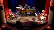 70 Jahre Musik der Zeit: Die Cellistinnen Karolina Öhman und Lisa Hofer spielen mit dem Schlagzeuger Dino Georgeton auf der Bühne des Senftöpfchens