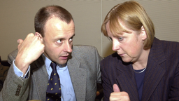 Friedrich Merz spricht mit Angela Merkel. 