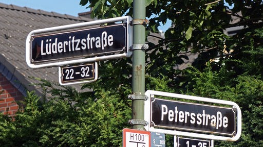 Strassennamen in Düsseldorf-Urdenbach: Adolf Lüderitz und Carl Peters, die beide im deutschen Kolonialismus in Afrika, heute Namibia und Tansania, aktiv waren.