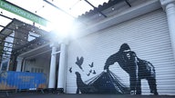 Der Street-Art-Künstler Banksy hat am Londoner Zoo einen Gorilla gesprayt, der einen Rollladen hochhält, aus dem mehrere Tiere entkommen. 