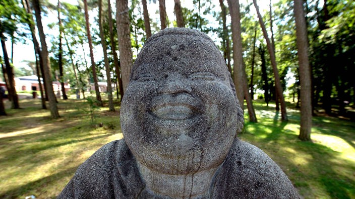 Die lachenden Buddha-Statue «Bonze des Humors» steht am 16.08.2013 in Worpswede (Niedersachsen) . Das steinerne Monument wurde 1914 von Bernhard Hoetger entworfen. Foto: Carmen Jaspersen/dpa