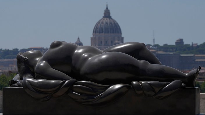 Boteros Skulptur am 19.07.2024 auf der Pincio-Terrasse in Rom,  im Hintergrund der Petersdom im Vatikan.