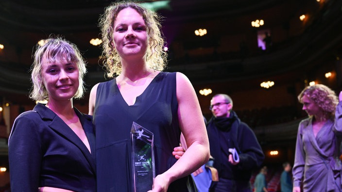 Chiara Fleischhacker (r), Gewinnerin in der Kategorie abendfŸüllender Spielfilm mit "Vena", steht nach der Verleihung des Nachwuchspreises First Steps Award 2024 im Theater des Westens mit Lisa Jilg, 