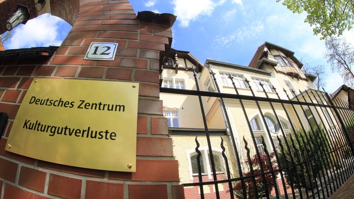 Der Sitz des Deutschen Zentrums Kulturgutverluste in Magdeburg, aufgenommen am 28.04.2015. Man sieht das Gebäude mit Tor und einem Schild "Deutsches Zentrum Kulturgutverluste".